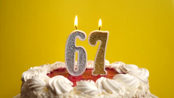番号67の形でキャンドルは 休日のケーキに挿入され 吹き飛ばされます 誕生日やランドマークイベントを祝う お祝いのクライマックス — ストック動画