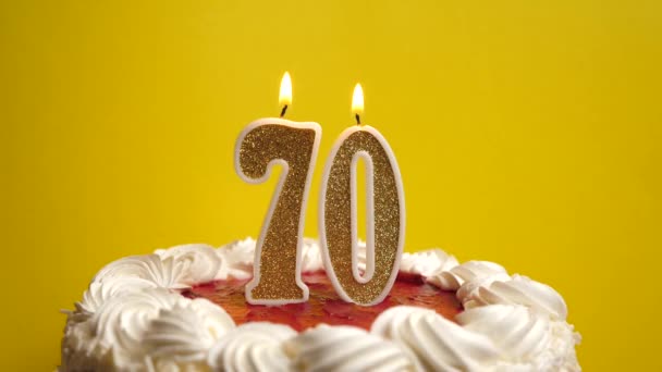 70番の形のキャンドルは 休日のケーキに挿入され 吹き飛ばされます 誕生日やランドマークイベントを祝う お祝いのクライマックス — ストック動画
