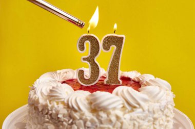 37 numaralı pasta şeklinde bir mum, şenlikli bir pastaya sıkıştı ve yakıldı. Bir doğum gününü ya da tarihi bir olayı kutluyoruz. Kutlamanın doruk noktası..