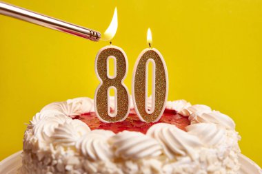 80 numara şeklinde bir mum, şenlikli bir pastaya sıkıştı ve yakıldı. Bir doğum gününü ya da tarihi bir olayı kutluyoruz. Kutlamanın doruk noktası..