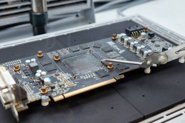 Kızılötesi lehimleme istasyonu kullanan yeni lehimlenmiş GPU çipli bir video kartı. Bilgisayar ekipmanlarının bakımı ve onarımı.