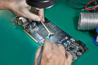 GPU çipini lehimlemek için video kartın iletişim grubunu temizliyorum. Lehim demiri C245. Bilgisayar ekipmanlarının bakımı ve onarımı.