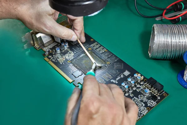 stock image Cleaning the contact group of the video card for soldering the GPU chip. Soldering iron C245. Maintenance and repair of computer equipment.