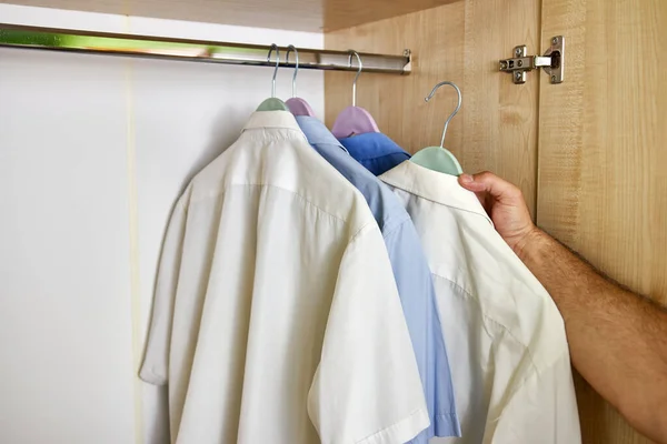 Der Mann Öffnet Den Kleiderschrank Und Wählt Ein Hemd Aus — Stockfoto