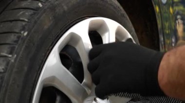 Arabanın tekerlek kenarına dekoratif bir kapak takılı. Arabaların bakımı ve bakımı.