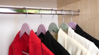 Kadın dolabı açar ve elbiselerini çıkarır..