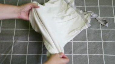 Beyaz yıkanmış bir tişört düzgünce katlanmış. Ev ödevi.