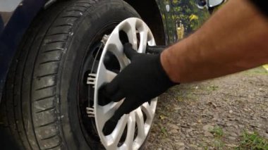 Arabanın tekerlek kenarına dekoratif bir kapak takılı. Arabaların bakımı ve bakımı.