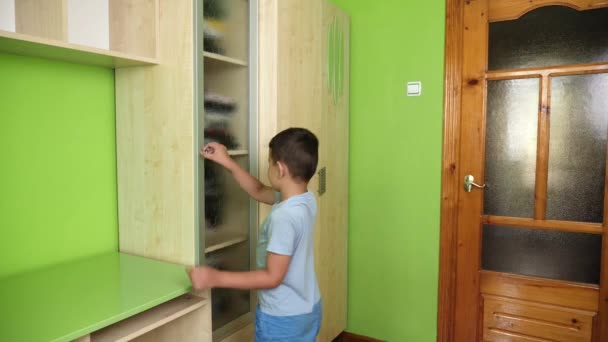Хлопець Відкриває Двері Шафи Виймає Шорти Полиці — стокове відео