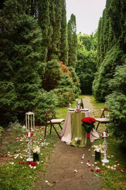 Ormanın ortasındaki çimenlikte şölen masası. Evlilik teklifi sırasında romantik ve şenlikli bir ortam..   