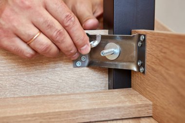 Masa bacağı vidayla tutturulmuş. Mobilyaların kurulumu ve ayarlanması.