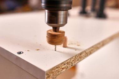 Mobilya bacakları takmak için delik aç. Dolap mobilyalarının montajı.