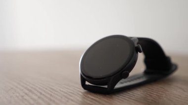 Adam masadan siyah bir saat alıyor. Şık erkek aksesuarları..