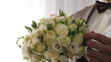 Damat elinde tutarak düğün buketine bakar. Düğün hazırlıkları..