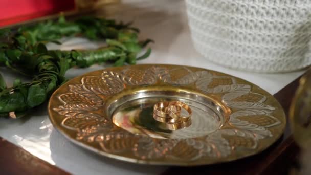 Arany Jegygyűrűk Egy Tányéron Egy Templomi Esküvő Alatt — Stock videók