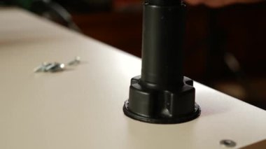 Mobilya bacakları tornavidayla tutturulmuş. Dolap mobilyalarının montajı.