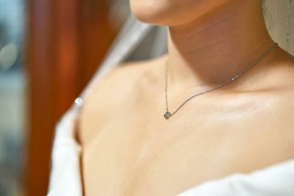 A bride with a chain and a pendant around her neck. Wedding celebration.