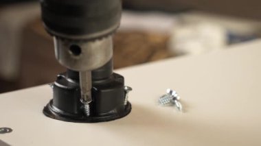 Mobilya bacakları tornavidayla tutturulmuş. Dolap mobilyalarının montajı.