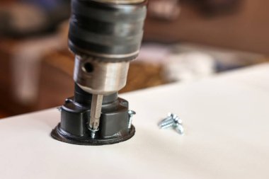 Mobilya bacakları tornavidayla tutturulmuş. Dolap mobilyalarının montajı.