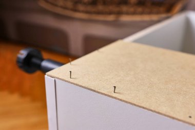 Dolabın arka duvarı çivi ve çekiçle çivilenmiş. Dolap mobilyalarının montajı.