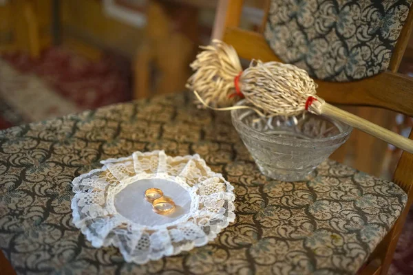 stock image On the chair is a tray with golden wedding rings on holy water for consecration.                              