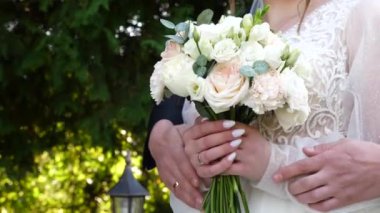 Bir erkek elinde buket tutan bir kadının ellerine sarılır. Aşk ve romantik ilişkiler.