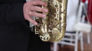 Siyah ceketli bir adam saksafon çalar. Yavaş çekim videosu.