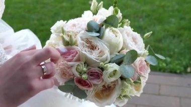 Gelin buketin çiçeklerine nazikçe dokunur. Aşk ve romantik ilişkiler.
