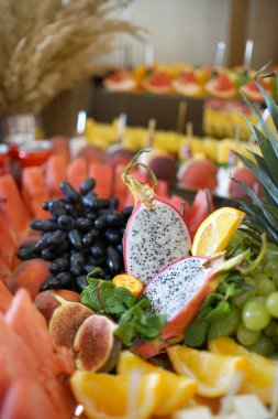 Bayramlık meyve büfesi. Açık büfe masasının dekorasyonu. Üzüm, ananas, portakal ve diğer meyveler.                               