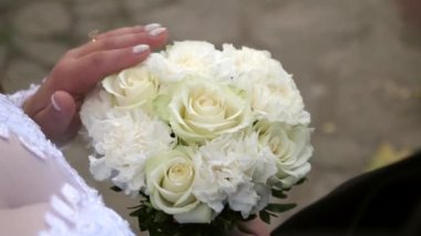 Gelin buketin çiçeklerine nazikçe dokunur. Aşk ve romantik ilişkiler.