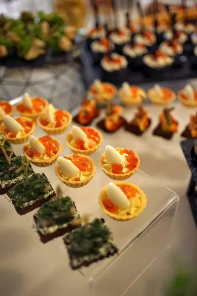 Buffet table with sandwiches with cheese, caviar and eggs.
