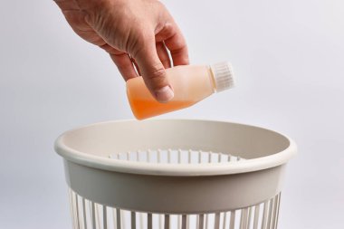 Tarihi geçmiş tıbbi şurubu olan plastik bir şişe geri dönüşüm için çöpe atılıyor..