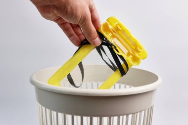 Kırık bir plastik su geçirmez akıllı telefon kutusu geri dönüşüm ya da imha için çöpe atılır..