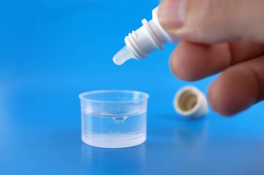 Tıbbi çözüm, ilacı suyla ölçme kabına damlatarak hazırlanır. Tedavi ve sağlığın önlenmesi.