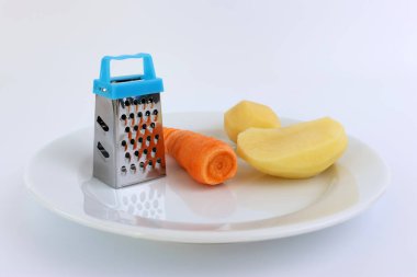 El yapımı minyatür rende, havuç ve patates, beyaz tabakta..