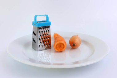 Beyaz tabakta rendelenmiş havuç ve soğan..