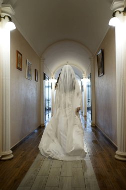 Gelin otel kompleksinin uzun koridorunda yürüyor. Düğün hazırlıkları..                               