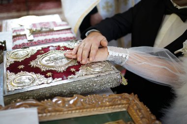 Birbirlerine kilise yemini ederken, yeni evliler İncil 'i ele geçirdiler. Kilise nikahı.                               
