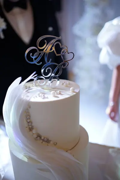 Wedding cake with the initials of the newlyweds. Wedding traditions.