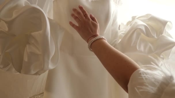 Невеста Нежно Касается Рукой Красивого Белого Свадебного Платья Висящего Комнате — стоковое видео