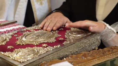 Kilise yemini sırasında, yeni evliler ellerini İncil 'e koydular..