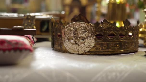 結婚式では 天使のイメージを持つ黄金の王冠が教会の王座に置かれています — ストック動画