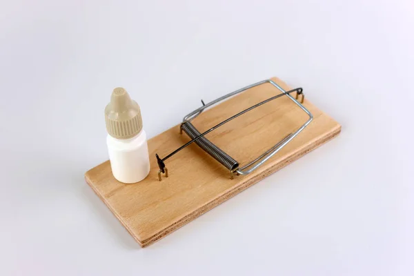A mousetrap with a bottle of medicine. The concept of drug addiction.