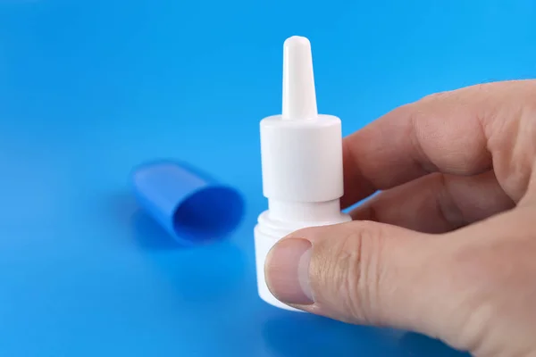 A bottle with medicine in the form of drops on a blue background.