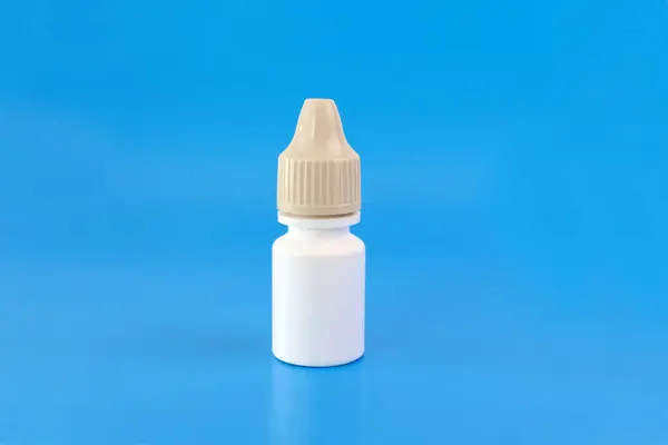 A bottle with medicine in the form of drops on a blue background.