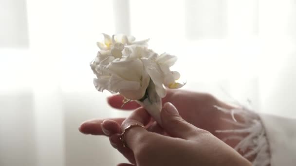 Νύφη Στέκεται Στο Παράθυρο Κρατώντας Ένα Μπουτονιέρα Στα Χέρια Της — Αρχείο Βίντεο
