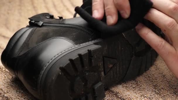 黒い革のブーツは 盗まれた布で汚れをきれいにしています シューケアの概念 — ストック動画