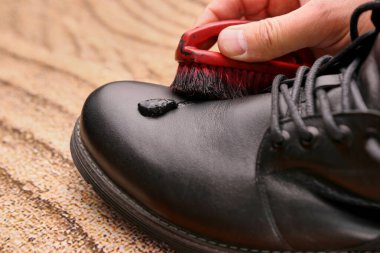 Siyah deri botlar ayakkabı kremiyle temizlenir. Ayakkabı bakımı kavramı.