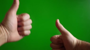 Bir adam yeşil arka planda iki eliyle 