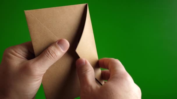 男性は緑の背景にある封筒にドルを数えています 金融犯罪という概念 スローモーション — ストック動画